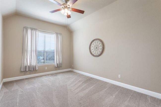 Empty room with baseboards, lofted ceiling, carpet, and ceiling fan | Image 30