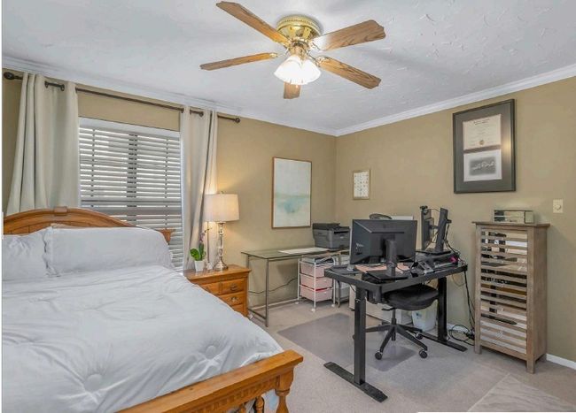 Bedroom featuring ceiling fan, baseboards, light colored carpet, and crown molding | Image 18