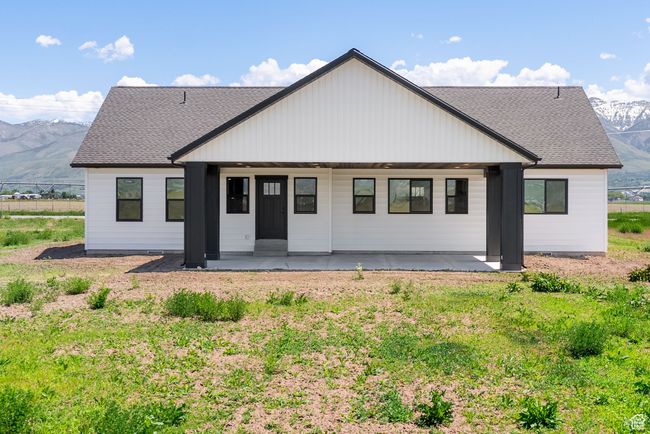 Rear view of house with a mountain view, a shingled roof, and a patio area | Image 18