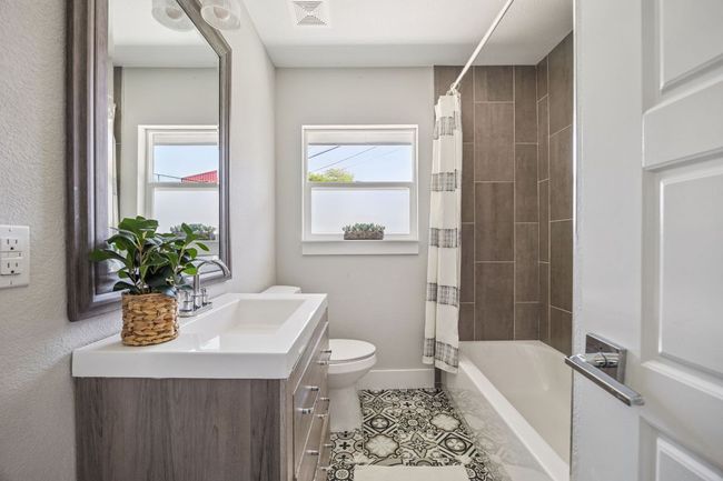 Bathroom with vanity, tile patterned flooring, and shower / bathtub combination with curtain | Image 31