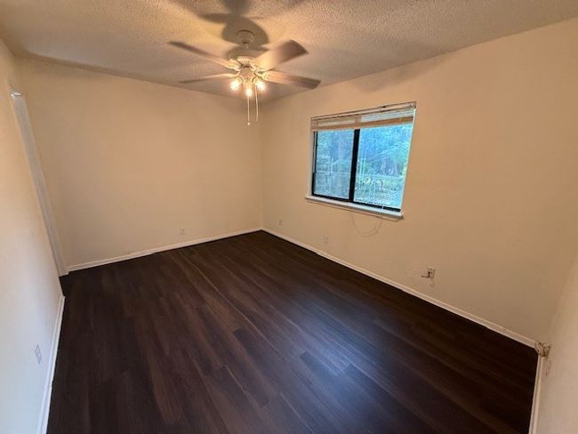 Spare room with a ceiling fan, dark wood finished floors, a textured ceiling, and baseboards | Image 6