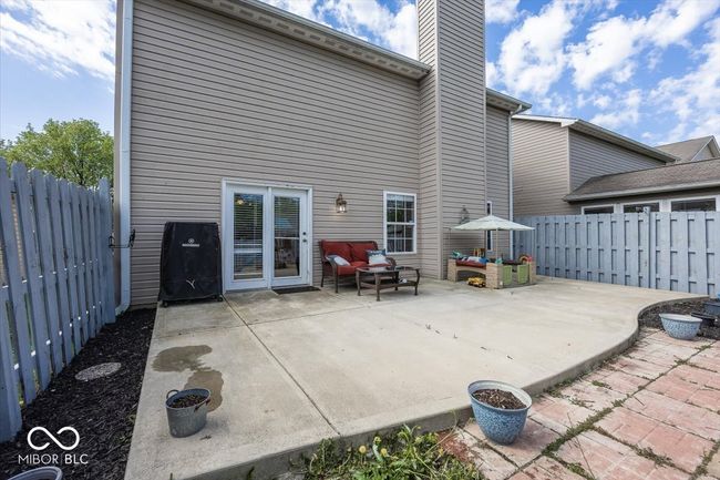 rear view of house with an outdoor hangout area, a fenced backyard, a chimney, and a patio | Image 24