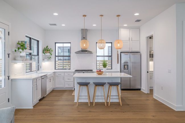 Kitchen with stainless steel appliances, farmhouse sink, center island with seating and open shelving | Image 8