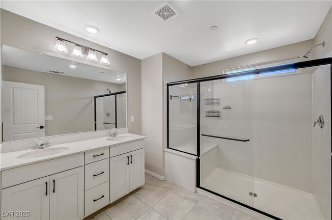 Bathroom featuring a stall shower, double vanity, and tile patterned floors | Image 40