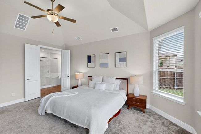 Bedroom with vaulted ceiling, connected bathroom, light carpet, and ceiling fan | Image 14