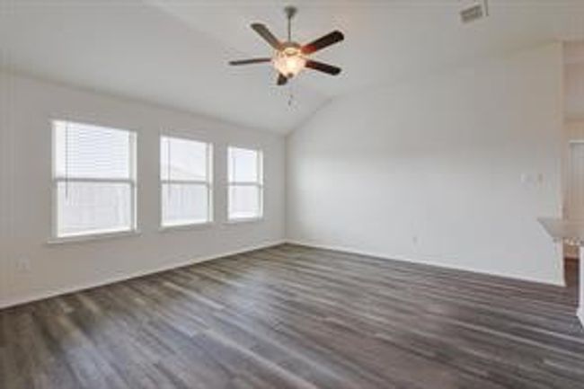 Unfurnished room with wood finished floors, lofted ceiling, and ceiling fan | Image 4