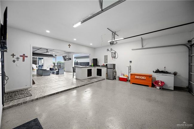 Garage with recessed lighting, a garage door opener, electric panel, and freestanding refrigerator | Image 9