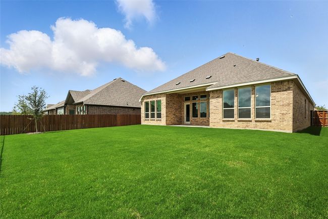 Rear view of property with a fenced backyard, brick siding, and a shingled roof | Image 29