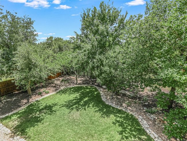 Enjoy serene views of the manicured backyard and green space from the upstairs balcony. | Image 25