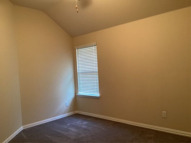 Unfurnished room featuring dark carpet, lofted ceiling, and baseboards | Image 30