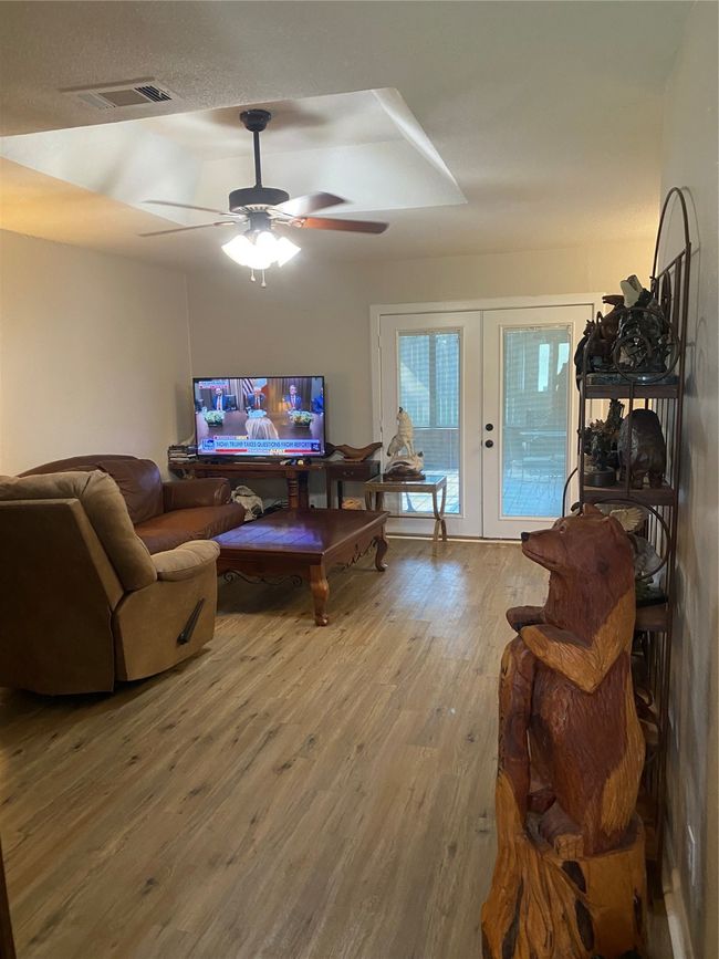 Living room featuring wood finished floors, visible vents, ceiling fan, and french doors | Image 6
