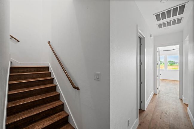 Stylish wooden staircase leads to the upper level, enhancing the home's charm and accessibility. | Image 32