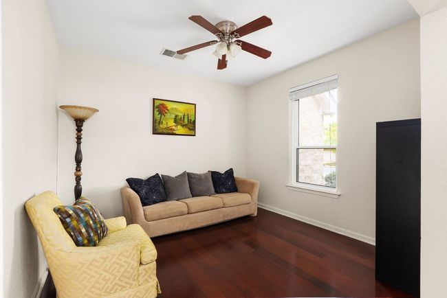Living room with ceiling fan, baseboards, dark wood finished floors, and visible vents | Image 14