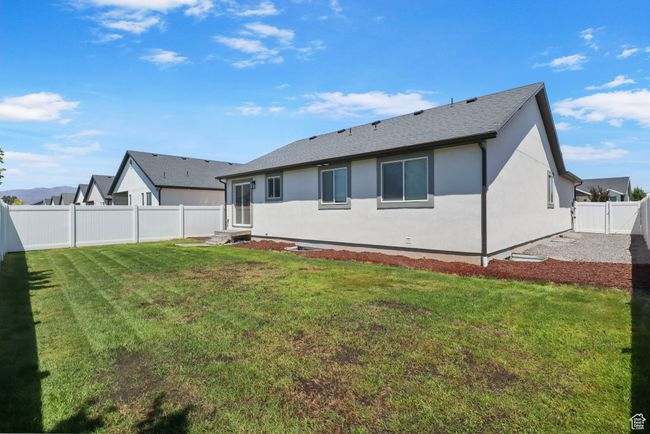 Back of house featuring a fenced backyard, stucco siding, entry steps, and roof with shingles | Image 23