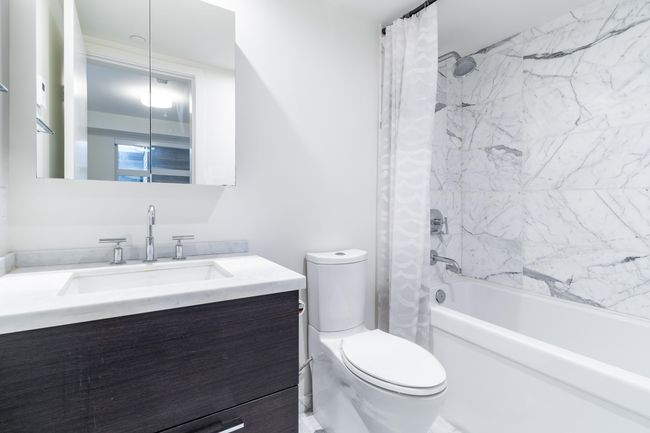 Laundry area featuring stacked washer / drying machine, water heater, light wood finished floors, and laundry area | Image 18