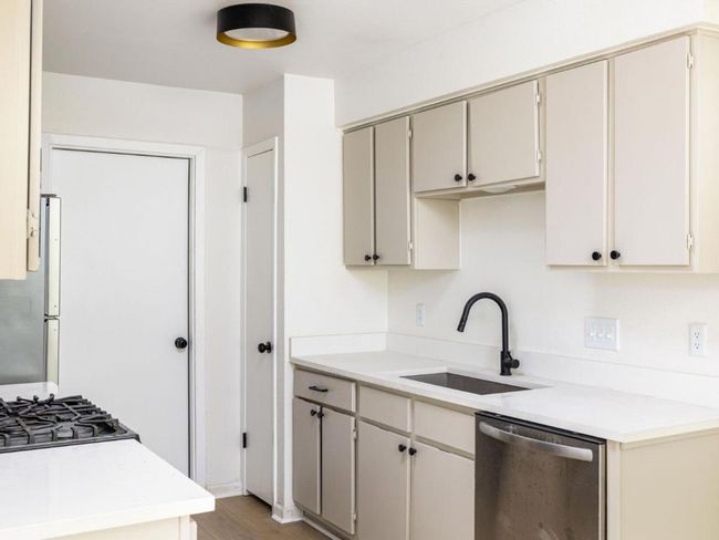 Kitchen featuring dishwasher, a sink, light countertops, and light wood-type flooring | Image 10