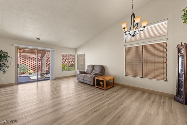 Unfurnished room featuring vaulted ceiling, light wood-style floors, a chandelier, and a textured ceiling | Image 18
