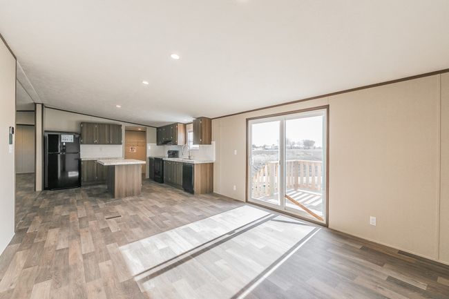 Kitchen is adjacent to the den. | Image 17