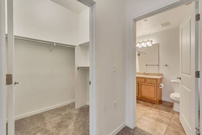 Interior space featuring light carpet, visible vents, light tile patterned flooring, and a sink | Image 19