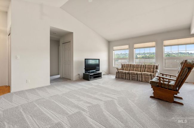 Living area with carpet flooring and vaulted ceiling | Image 6