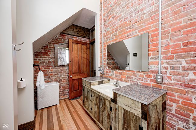 kitchen with light wood-style floors, brick wall, and a sink | Image 31