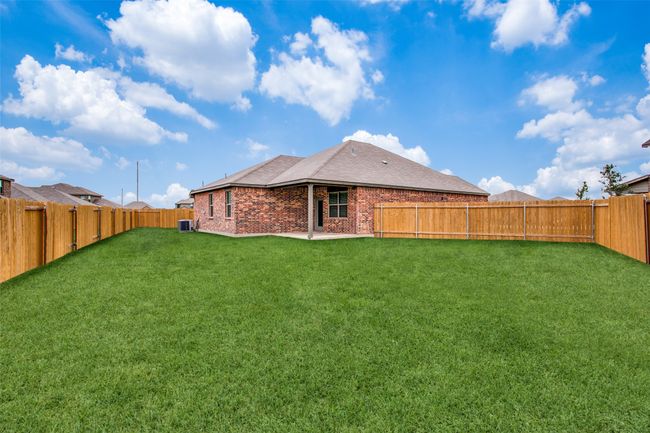 Back of property featuring brick siding, a yard, central AC, and a fenced backyard | Image 12