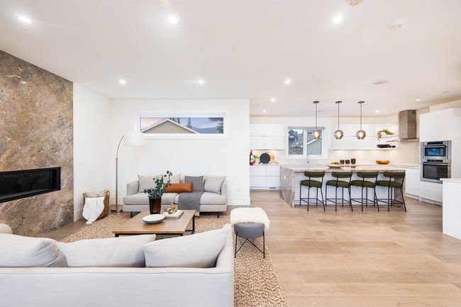 Living area with recessed lighting, light wood-style flooring, and a premium fireplace | Image 6