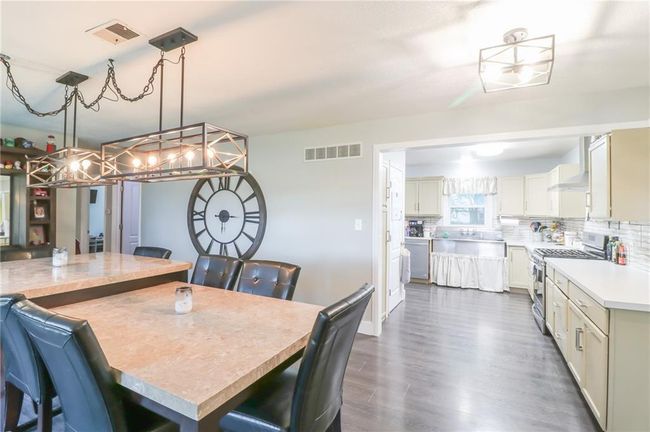 Dining space with a chandelier and dark wood-type flooring | Image 12