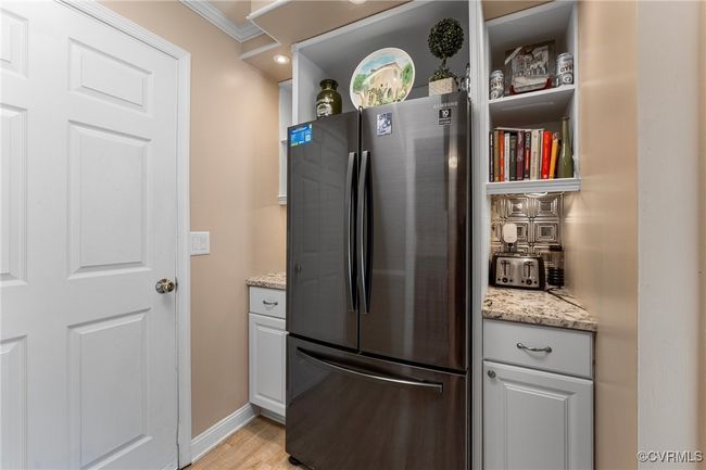 Kitchen with light stone counters, baseboards, light wood-type flooring, and freestanding refrigerator | Image 16