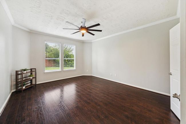 Suite retreat....this Primary Bedroom with crown molding, new ceiling fan (2/24), window blinds and beautiful engineered wood flooring offers a view to the bacjyard. | Image 29
