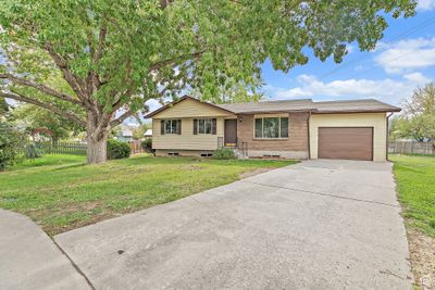 Ranch-style house with a front lawn and a garage | Image 3