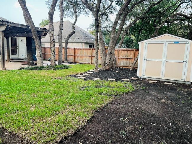 Fully Fenced backyard with a storage unit and a patio area with Pergola | Image 23