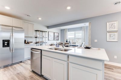 Thoughtfully designed kitchen with stainless appliance package including gas range, dishwasher and vented micro-hood. Photo of model home, color & options will vary. | Image 2