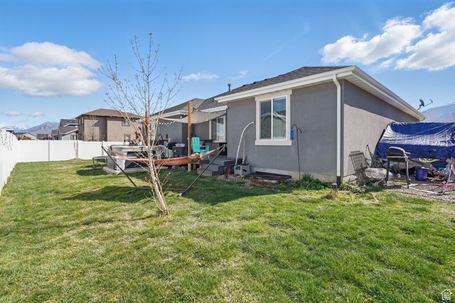Rear view of house featuring a yard, a fenced backyard, and stucco siding | Image 47