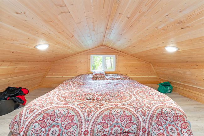 Bedroom with wood ceiling, wooden walls, wood finished floors, and lofted ceiling | Image 11
