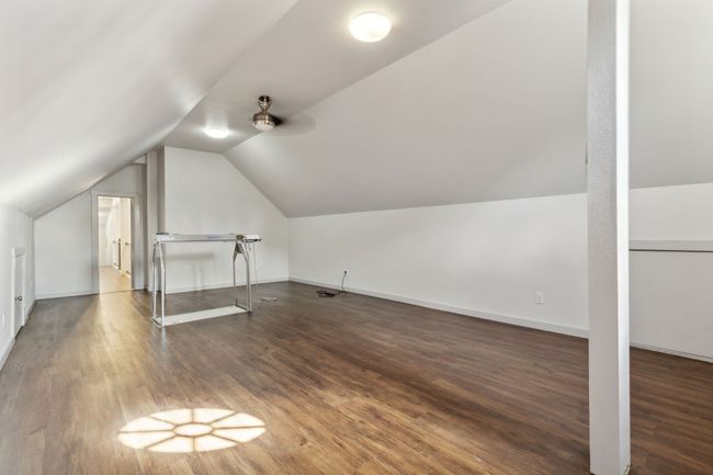 Bonus room featuring dark wood-type flooring and vaulted ceiling | Image 19