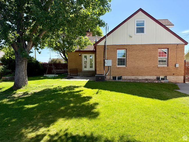 Back of house with brick siding, entry steps, french doors, and a shingled roof | Image 11