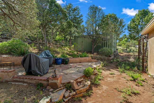 Fully fenced back yard with stone patio, one of two climate-controlled, electrified, and seismically qualified storage containers on permanent foundations with interior lighting | Image 38
