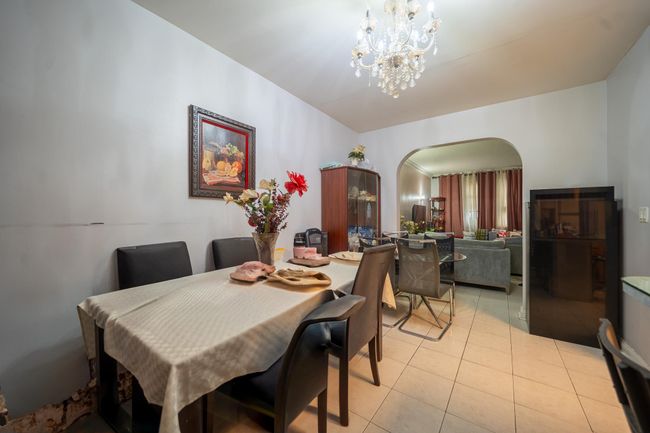 Dining room with arched walkways, light tile patterned floors, and a chandelier | Image 9