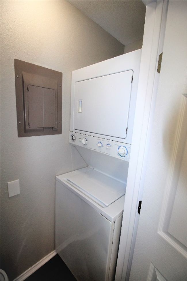 Laundry area with stacked washer / dryer and electric panel | Image 13
