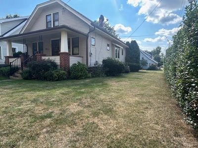 View of side of home featuring a lawn and covered porch | Image 3