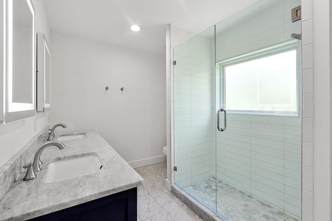 Full bathroom with a stall shower, a sink, and baseboards | Image 26