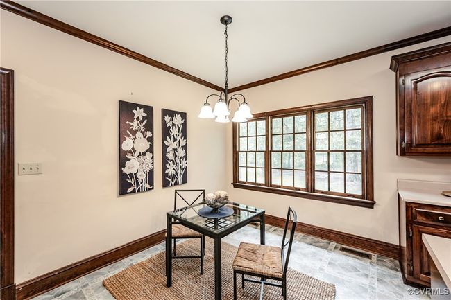 Dining room with baseboards, ornamental molding, and a chandelier | Image 25
