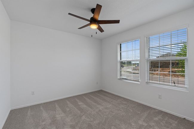 Carpeted empty room featuring a ceiling fan and baseboards | Image 17