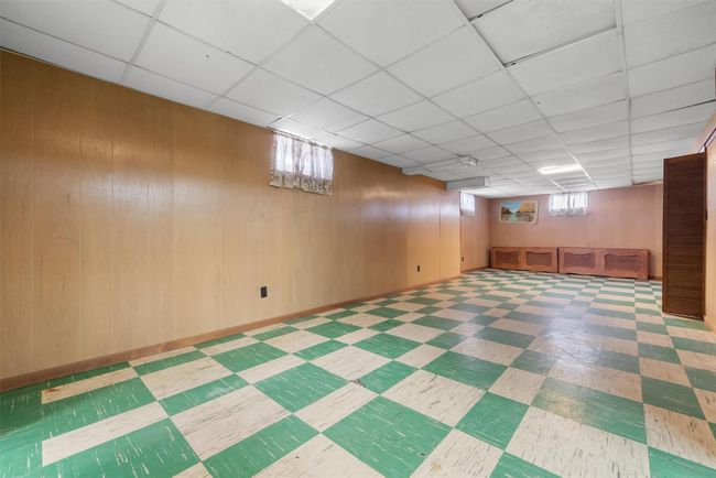 Below grade area with wooden walls, a paneled ceiling, and tile patterned floors | Image 26