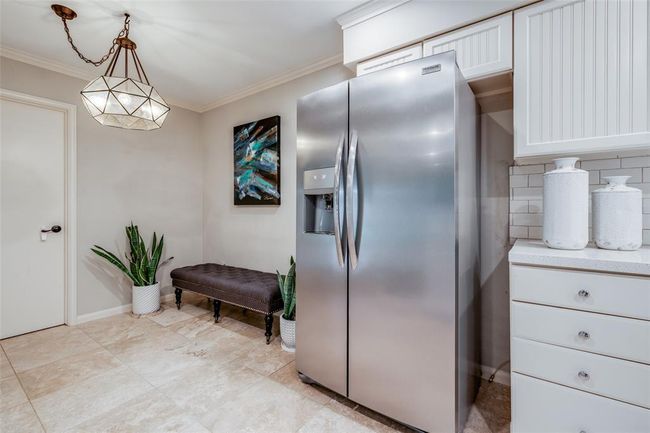 The breakfast nook is open to the kitchen, features a beautiful modern light pendant, tile flooring, crown molding throughout. Door through to Utility room & out to back yard & covered patio. | Image 15