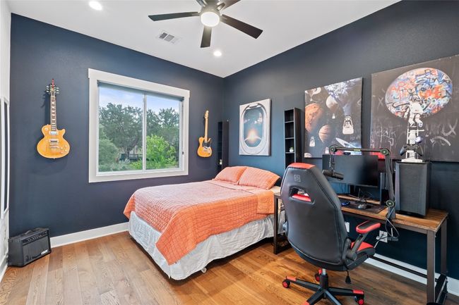 Bedroom with wood finished floors, an office area, recessed lighting, baseboards, and a ceiling fan | Image 24