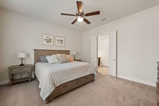 Bedroom with light colored carpet, baseboards, and ceiling fan | Image 13