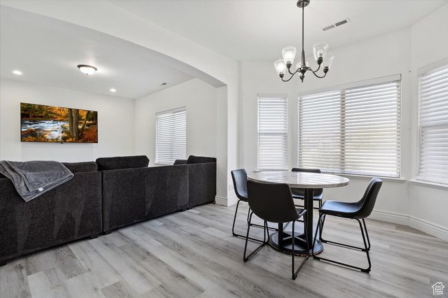 Dining area featuring a notable chandelier and light hardwood / wood-style flooring | Image 11