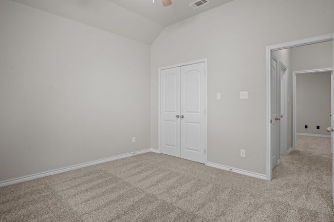 Unfurnished bedroom with a closet, visible vents, lofted ceiling, baseboards, and carpet | Image 28